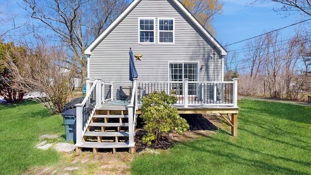 A two-story house with a balcony, a small tree in front, and a star decoration on the wall. - Dog-friendly home with deck, pool table, & firepit - walk to downtown Boothbay (Boothbay Harbor)