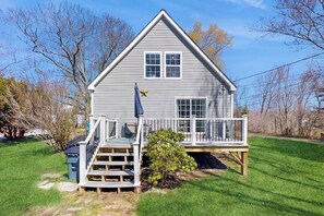 A two-story house with a balcony, a small tree in front, and a star decoration on the wall. - Dog-friendly home with deck, pool table, & firepit - walk to downtown Boothbay (Boothbay Harbor)
