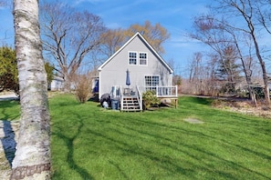 A single-story house with a front porch, a small deck, and a well-maintained lawn.