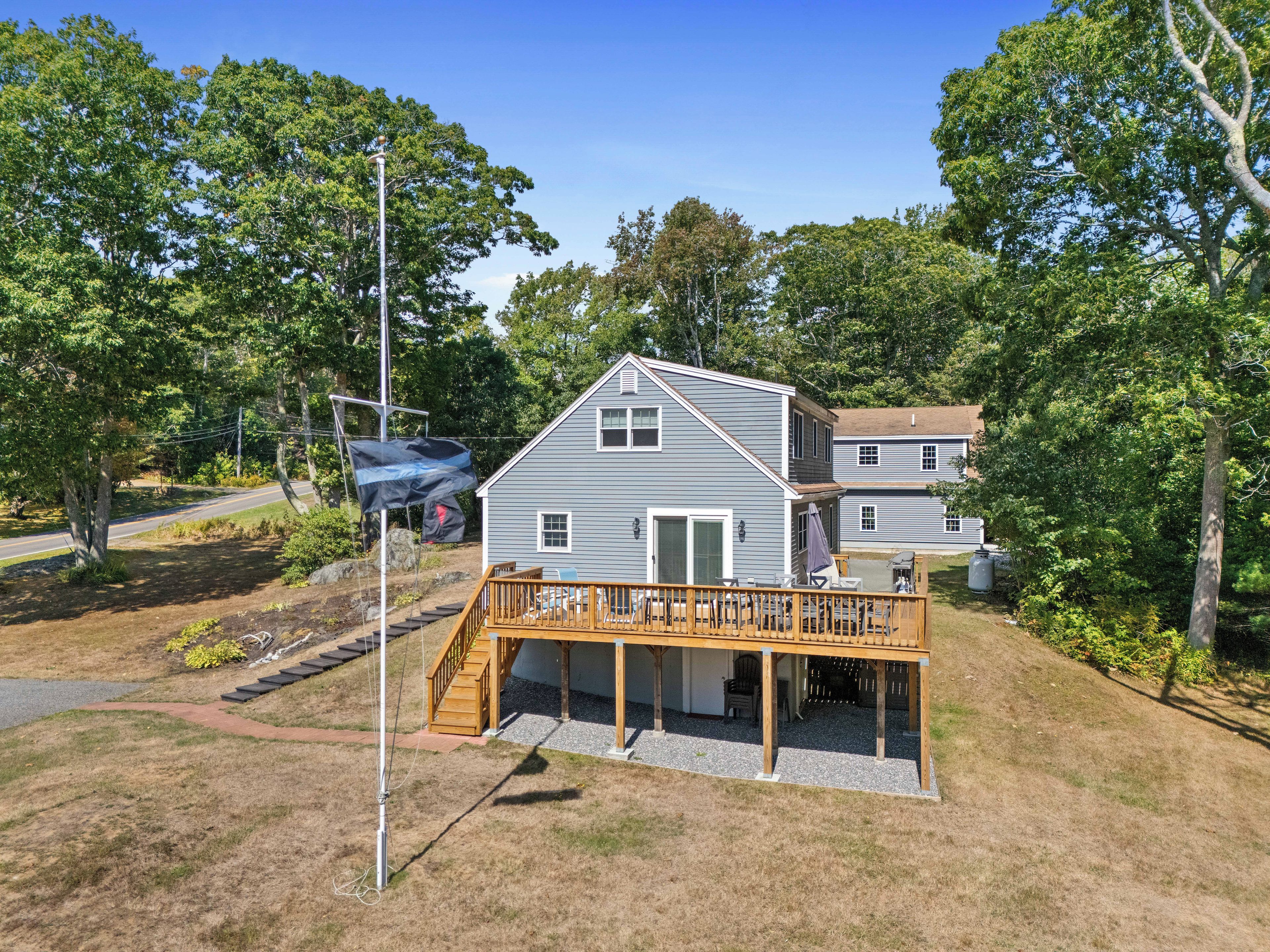 A two-story house with a wooden deck and a garage.