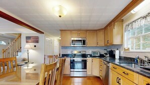 A kitchen with wooden cabinets, a stainless steel oven, a microwave, and a window with a view. - Boothbay Harbor Home with Water Views | Near Dining & Whale Watching (Boothbay Harbor)