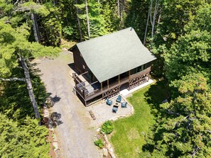 A lodge with a large deck, a covered patio, and a stone pathway leading to the entrance. - Sprucewold Cabin-  w/ Private Beach Club Access Dog-friendly (Boothbay Harbor)