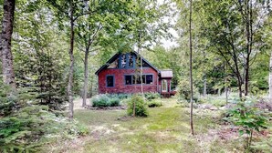 A rustic cabin surrounded by dense forest. - Dog-Friendly Lakefront Home w/ Deck, Firepit, Water Views & Games (Rockwood)