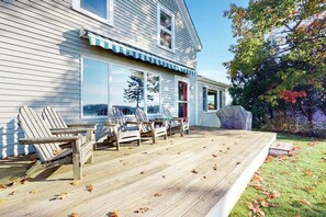 A house with a deck, outdoor seating, and a large window. - Bayfront house on Port Clyde Harbor with views, hot tub, beach access (St. George)