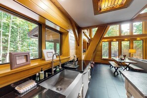 Eine Küche mit Spüle, Fenster und Holzschränken.