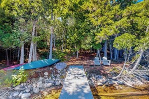 A wooden deck leading to a cabin surrounded by trees. - Dog-friendly lakefront home with deck, grill, WiFi, shared dock & water access (Greenville)