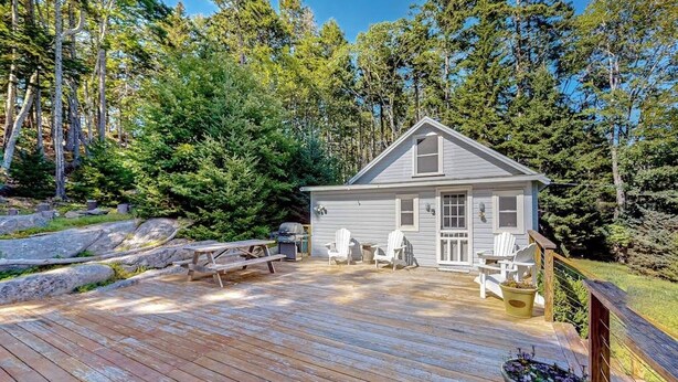 A cabin with a deck, surrounded by trees. - Sea View- Dog-friendly bay view home - water views (Boothbay Harbor)