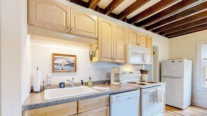 A kitchen with wooden cabinets, a white stove, a dishwasher, and a refrigerator. - Sea View- Dog-friendly bay view home - water views (Boothbay Harbor)
