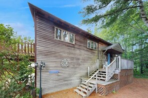 A rustic cabin with a wooden exterior, a porch, and a staircase leading to the entrance. - Cute cottage with fast WiFi & full kitchen - 1 mile to downtown & next to Acadia (Bar Harbor)