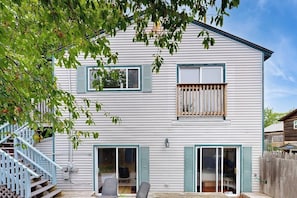 Ein zweistöckiges Haus mit Veranda, Treppe und Balkon.