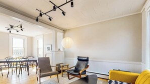 Ein geräumiges Zimmer mit Essbereich, einer Couch und einem Sessel.
