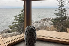 A room with a large window overlooking a rocky shoreline and the sea. - Spectacular oceanfront retreat with amazing views, sunroom & washer/dryer (Georgetown)