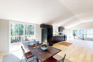 A spacious kitchen with a dining area, large windows, and a view of the outdoors.