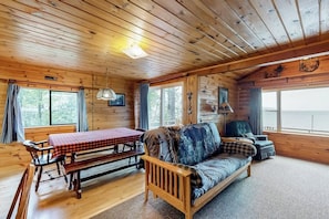 A cabin interior with a wooden bench, sofa, and table with a red checkered tablecloth. - Lake front home with privately shared dock for the homes in this complex (Greenville)