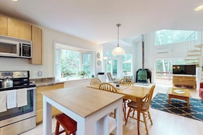 Une cuisine moderne dotée d’un îlot central, de meubles en bois, d’un four à micro-ondes et d’une cuisinière.
