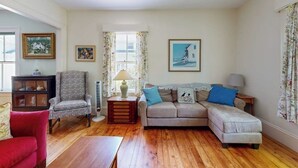 Una sala de estar con sofá, sillón y una mesita.