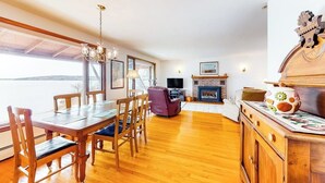Un coin repas avec des meubles en bois, une cheminée et un téléviseur.