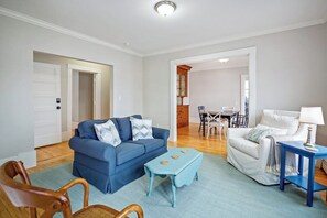 Un salon avec un canapé bleu, un fauteuil assorti, une petite table et une lampe.