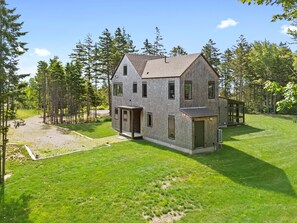 A two-story house with a large front yard, surrounded by trees. - Quiet, modern, dog-friendly home with ocean views, private trails & firepit (St. George)