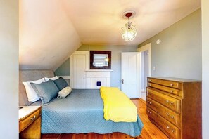 Een slaapkamer met een bed, een kaptafel en een kroonluchter.