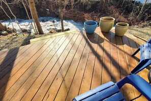 Une terrasse en bois agrémentée de plantes en pot et de chaises.