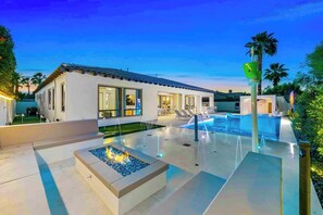 A modern house with a swimming pool, outdoor seating, and a fire feature. - Valhalla/Game Room/Waterslide (Indio)