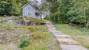 Una casa con una escalera de piedra que lleva a un porche.