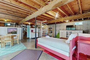 Een kamer met een bed, bureau, stoel, trap en televisie.