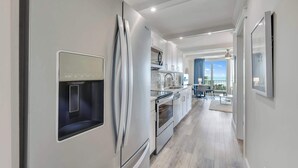 Een moderne keuken met een inbouwkoelkast, oven en magnetron.