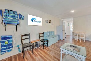 Une pièce comprenant un lit, une chaise, une petite table, un radiateur et une enseigne indiquant « Big Fish Rentals ».