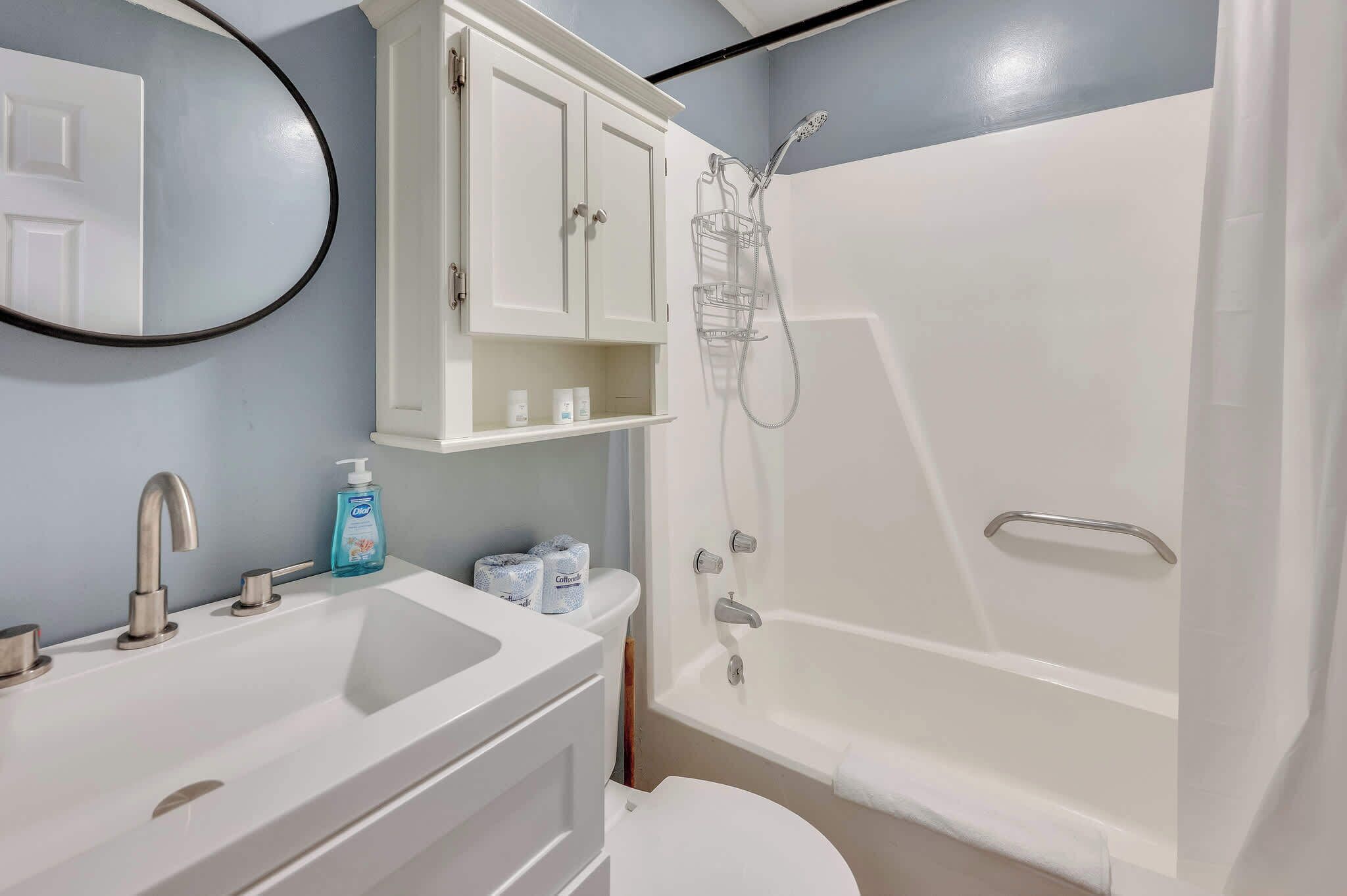 Une salle de bain avec un lavabo, des toilettes et une douche.