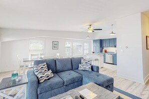 A living room with a sofa, coffee table, and dining area. - Oceanfront, dog-friendly condo with Boothbay Harbor views & prime location (Boothbay Harbor)