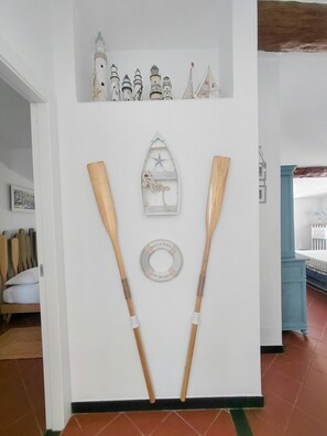 Eine Wand mit einer maritimen Dekoration, darunter ein Schiff, ein Rettungsring mit der Aufschrift 'WELCOME ON BOARD' und zwei Holopaddel.