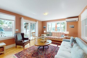 Un salon comprenant un canapé, un fauteuil, une table basse et un tapis à motifs.