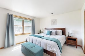 A bedroom with a bed, bedside tables, a window with curtains, and a wall-mounted artwork. - Charming Lakefront House with Outdoor Firepit, Washer/Dryer and Wifi (Gouldsboro)