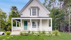 A white two-story house with a porch, a green door, and a small window above the door. - Charming Camden Retreat with Front Porch, Deck and Wifi (Camden)