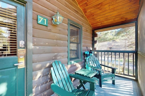 A wooden cabin with a porch, two Adirondack chairs, a number '71' sign, and a window with shutters. - Dog-friendly cabin retreat with kitchen, firepit, hiking & outdoor fun (Northport)