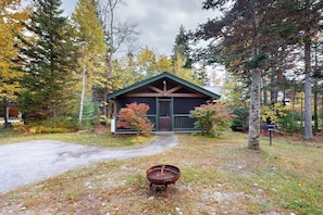 A cabin with a green roof, a wooden door, and a porch. - Idyllic dog-friendly studio cabin with AC, fireplace & WiFi (Northport)