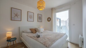Ein Schlafzimmer mit Bett, Nachttisch, Lampe und einem gerahmten Kunstwerk an der Wand.