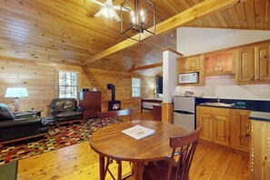 Ein Ferienhaus-Innenraum mit Wohnzimmer, Essbereich, Küche und Kamin.