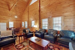 Ein Holzblockhaus-Interieur mit Wohnbereich, Essbereich und Küche.