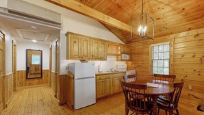 Un interno in legno con cucina, zona pranzo e un corridoio.