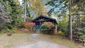 Eine Hütte mit Veranda, Treppe und einem Kiesweg, der dorthin führt.