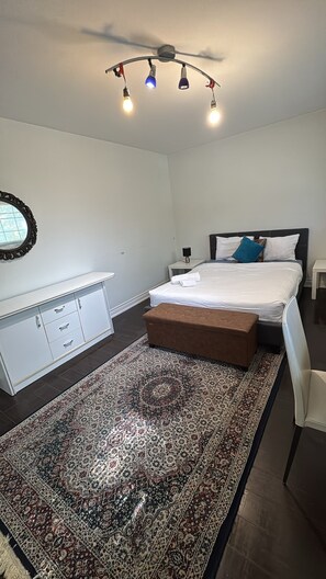 A bedroom with a bed, bedside table, lamp, nightstand, dresser, mirror, and a ceiling fan with lights. - Private Room in North York | Shared Bath (Toronto)