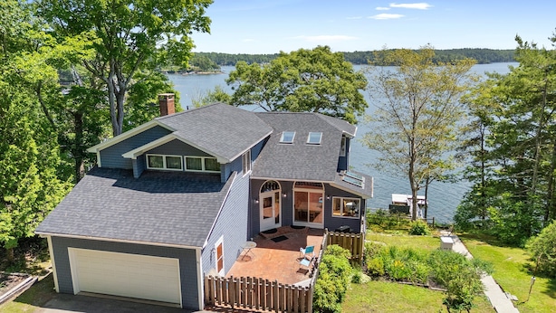 A two-story house with a garage, a deck, and a view of a lake. - High View- Serene waterfront home w/ a dock, large deck & amazing views! (Harpswell)