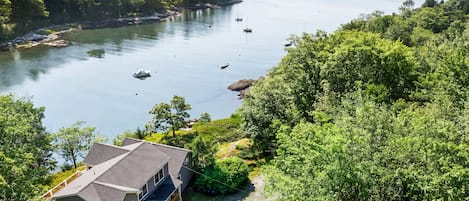 Ett hus med en balkong som vetter ut mot en sjö där det finns båtar.