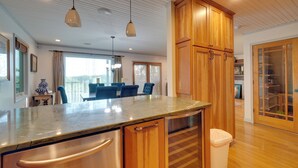 A kitchen with wooden cabinets, a marble countertop, and stainless steel appliances.