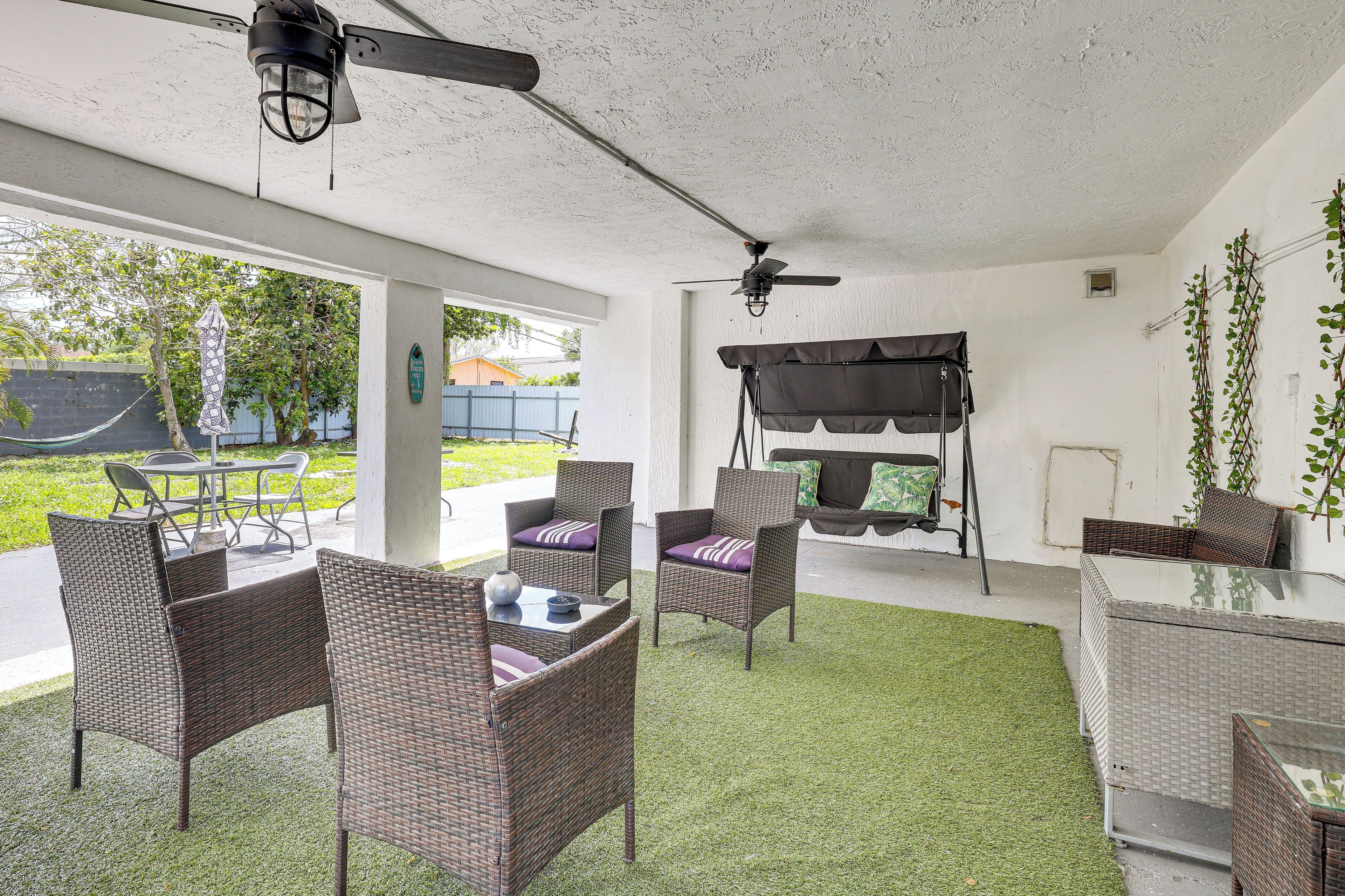 An outdoor patio with wicker furniture, a ceiling fan, and a barbecue grill.