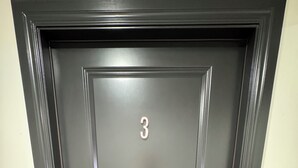 A dark-colored door with the number 3 on it, a keypad lock, and a small rectangular panel below the door. - Perfect place to stay for events at the Lazy E! (Guthrie)