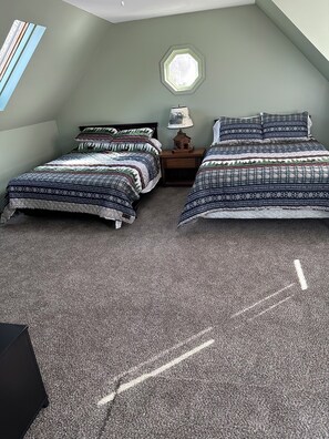 A bedroom with two beds, a window, and a nightstand with a lamp. - Cozy 2-bedroom cottage in serene Dingmans Ferry with AC (Dingmans Ferry)